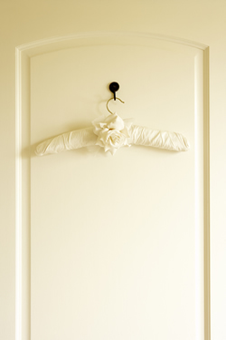 Photo of a white wardrobe door with a padded clothes hanger decorated with a rose